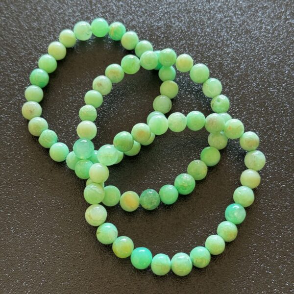Bright apple green chrysoprase crystal with a smooth, polished surface and gentle translucency, often associated with emotional renewal, calmness, and a fresh sense of optimism.